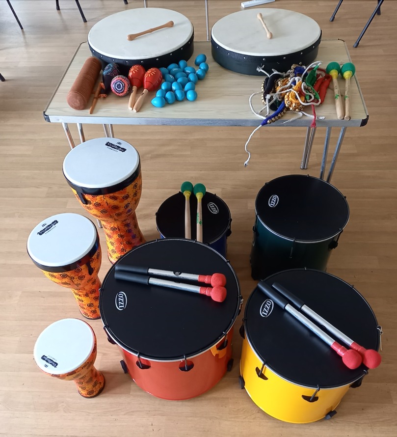 A collection of musical instruments including drums, egg shakers, maracas and bells